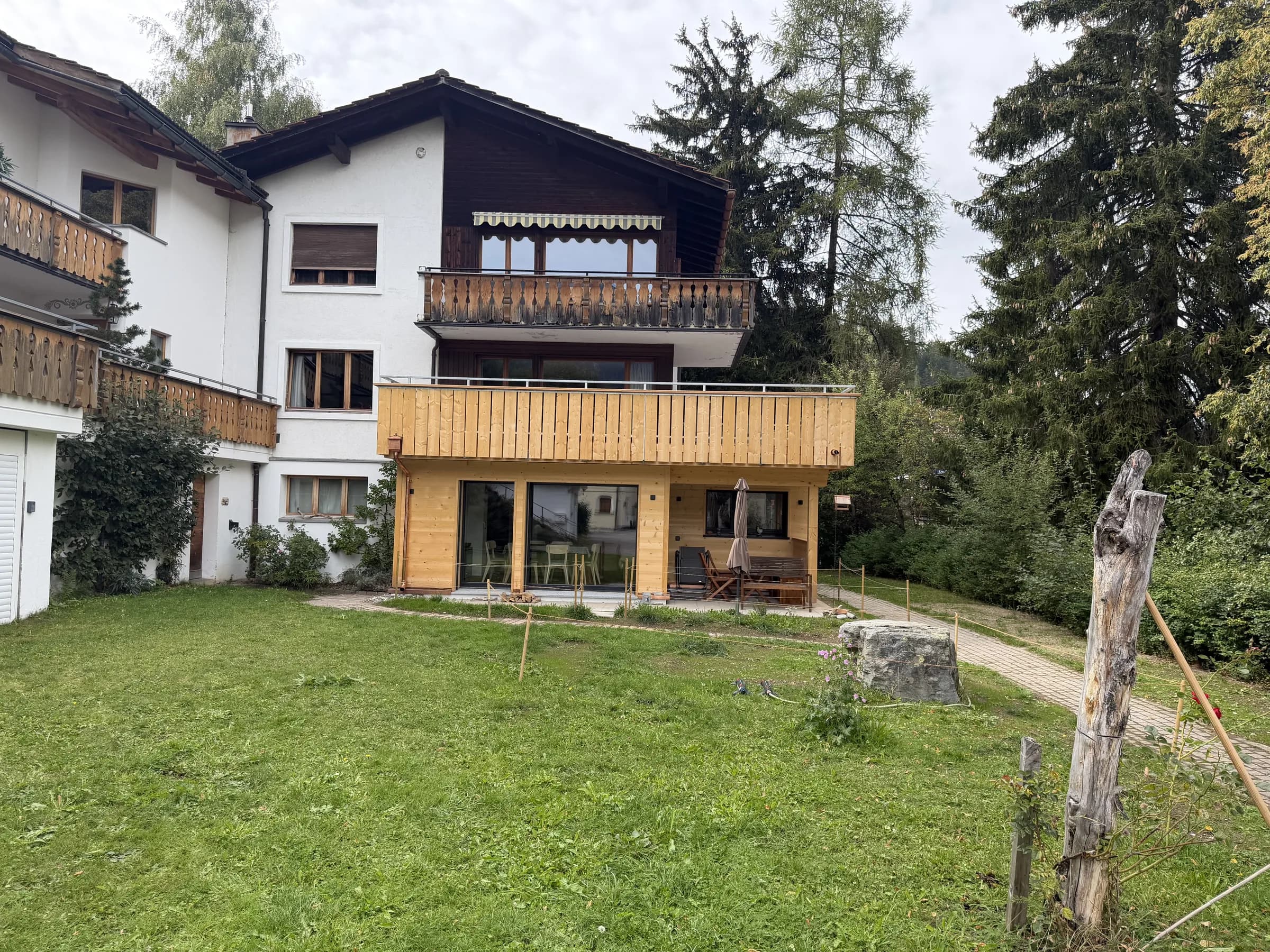 Der neue Holzanbau im Erdgeschoss mit gedecktem Sitzplatz
