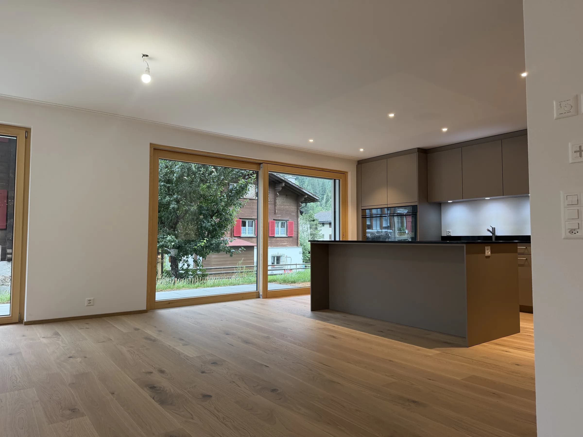 Wohnen und Kochen mit grossen Fenstern zum Garten