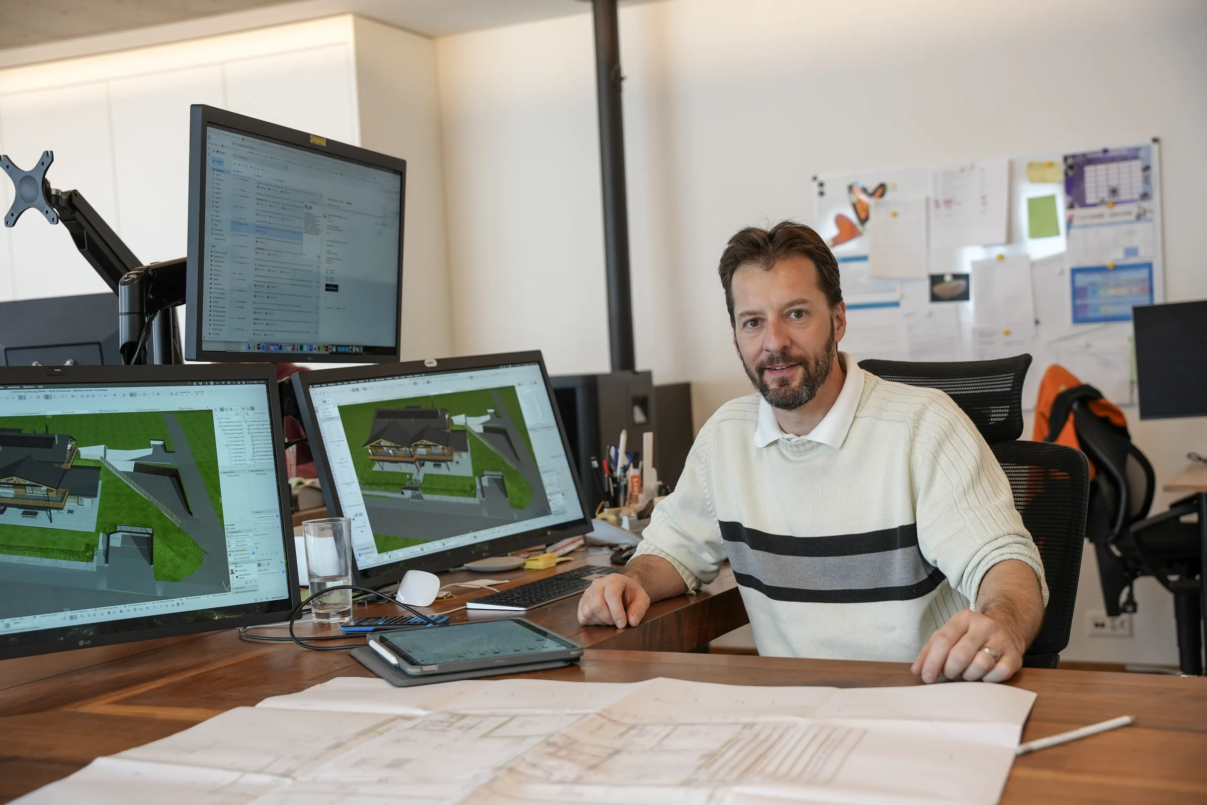 Yvan Rüedi am Arbeitsplatz mit Plänen und 3D-Modell